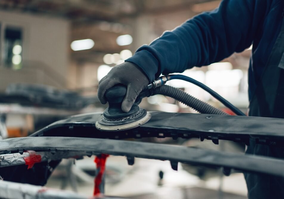 Auto Mechanic Straightening Car Body In Car Service Station