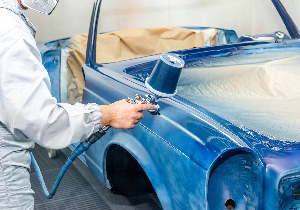 Person spray painting convertible